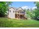 Backyard view of two-story home with screened porch and spacious deck, ideal for relaxation and outdoor enjoyment at 68 Tanners Way, Clayton, NC 27527