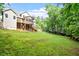 Spacious backyard with lush lawn, mature trees, wood fence, deck and screened porch on a traditional two-story home at 68 Tanners Way, Clayton, NC 27527