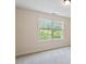 Bright bedroom featuring neutral walls and a window offering a view of the lush greenery outside at 68 Tanners Way, Clayton, NC 27527