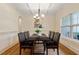 Dining room featuring trey ceilings, modern chandelier, large windows, wainscoting and hardwood floors at 68 Tanners Way, Clayton, NC 27527