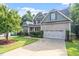 Lovely two-story home boasting a well-kept lawn, mature trees, and an attached two-car garage at 68 Tanners Way, Clayton, NC 27527