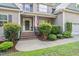 Inviting front porch with brick steps, lush greenery, and classic architectural details, showcasing curb appeal at 68 Tanners Way, Clayton, NC 27527