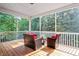 Inviting screened porch with wicker furniture and a view of the surrounding trees at 68 Tanners Way, Clayton, NC 27527