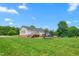 Wide backyard featuring green grass, mature trees, a trampoline, playset, RV, and a house with a deck at 724 Harolds Northfield Dr, Cedar Grove, NC 27231