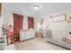 Bedroom with curtains, a crib, a playhouse, and a dresser with a changing table on top at 724 Harolds Northfield Dr, Cedar Grove, NC 27231