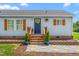 Inviting front porch with lovely plants and a decorative wreath enhancing the entryway appeal at 724 Harolds Northfield Dr, Cedar Grove, NC 27231