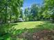 A large backyard offers plenty of space and is surrounded by mature trees for privacy and shade at 7605 Copper Mine Ln, Raleigh, NC 27615