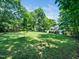 Spacious backyard boasts lush green grass, mature trees, and plenty of room to add custom landscaping at 7605 Copper Mine Ln, Raleigh, NC 27615