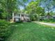 Inviting two-story home with a green lawn, mature trees, and a charming exterior at 7605 Copper Mine Ln, Raleigh, NC 27615
