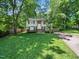 Charming two-story home with mature trees, a yellow front door, and a well-manicured lawn at 7605 Copper Mine Ln, Raleigh, NC 27615