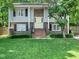 Charming two-story home with brick accents, a welcoming yellow door, and a well-manicured lawn at 7605 Copper Mine Ln, Raleigh, NC 27615