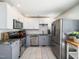 Modern kitchen with stainless steel appliances, granite countertops, and stylish two-tone cabinetry at 7605 Copper Mine Ln, Raleigh, NC 27615