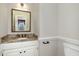 Half-bathroom with granite vanity and framed mirror at 7801 Wood Way Ct, Raleigh, NC 27606