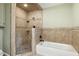 Modern bathroom with tiled walk-in shower and adjacent tub at 7801 Wood Way Ct, Raleigh, NC 27606