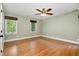 Bedroom with hardwood floors, ceiling fan, two windows, and neutral walls at 7801 Wood Way Ct, Raleigh, NC 27606