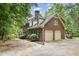 Stately brick home showcasing a two-car garage and lush, mature landscaping at 7801 Wood Way Ct, Raleigh, NC 27606