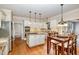 White kitchen with center island, stainless steel appliances, and dining area at 7801 Wood Way Ct, Raleigh, NC 27606