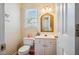 Half-bathroom with charming wallpaper, a gold-framed mirror, and a toilet, offering a touch of elegance at 9 Lake Village Dr, Durham, NC 27713
