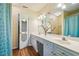 Bright bathroom featuring a double sink vanity, decorative mirror, and wood floors at 9 Lake Village Dr, Durham, NC 27713
