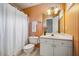 Bathroom with striped wallpaper, white fixtures, vanity, and shower with curtain at 9 Lake Village Dr, Durham, NC 27713