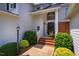 Welcoming home entrance with brick steps, lush landscaping, and a stylish front door at 9 Lake Village Dr, Durham, NC 27713