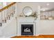 Elegant fireplace with white mantel, round mirror, and staircase alongside at 9 Lake Village Dr, Durham, NC 27713