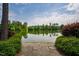 Scenic lake view surrounded by lush greenery and blue sky, enhanced by a stone path at 9 Lake Village Dr, Durham, NC 27713