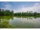 Calm lake view with reflections of trees and sky, showcasing the natural beauty of the community at 9 Lake Village Dr, Durham, NC 27713