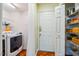 Functional laundry area with a modern washer, shelves for storage, and stylish herringbone flooring at 9 Lake Village Dr, Durham, NC 27713