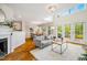 Bright living room with fireplace, herringbone floors, and access to the outdoor deck at 9 Lake Village Dr, Durham, NC 27713