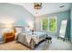 Cozy main bedroom featuring a tray ceiling, large window, and tasteful decor at 9 Lake Village Dr, Durham, NC 27713
