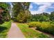 Scenic view of a walking path winding alongside a serene lake with lush greenery and trees at 9 Lake Village Dr, Durham, NC 27713