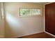 Well-lit bedroom with hardwood floors, white walls, and a view of the yard at 912 Dixie Trl, Raleigh, NC 27607