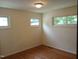 A brightly lit bedroom featuring hardwood floors, white walls, and multiple windows at 912 Dixie Trl, Raleigh, NC 27607