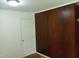 Bedroom with wooden paneling and a white closet door at 912 Dixie Trl, Raleigh, NC 27607