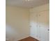 Neutral bedroom featuring two white doors, wood floors, and ample natural light from windows at 912 Dixie Trl, Raleigh, NC 27607