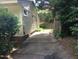 Property showing driveway access alongside house with green shrubs and mature trees at 912 Dixie Trl, Raleigh, NC 27607