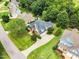 Aerial view of a beautiful brick home with mature landscaping, a long driveway, and a two-car garage at 921 Riverwood Dr, Clayton, NC 27527