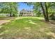 A lush backyard with a well-manicured lawn and a charming home featuring a screened porch and deck at 921 Riverwood Dr, Clayton, NC 27527