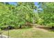 Lush backyard with mature trees, a well-maintained lawn, and a tranquil setting at 921 Riverwood Dr, Clayton, NC 27527