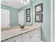 A well-lit bathroom featuring a single sink vanity with white cabinets and decoratively framed artwork at 921 Riverwood Dr, Clayton, NC 27527