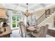 Dining room showcases a coffered ceiling, wooden chandelier, a staircase, and natural light from large windows at 921 Riverwood Dr, Clayton, NC 27527
