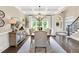Formal dining room featuring a coffered ceiling, elegant chandelier, staircase, and bright natural lighting at 921 Riverwood Dr, Clayton, NC 27527