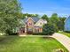 Charming brick home with lush landscaping, mature trees, and inviting curb appeal at 921 Riverwood Dr, Clayton, NC 27527