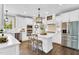 Elegant white kitchen featuring stainless steel appliances, quartz countertops, and an island with pendant lighting at 921 Riverwood Dr, Clayton, NC 27527