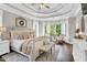 Bright main bedroom featuring tray ceilings, hardwood floors, sitting area, and an abundance of natural light at 921 Riverwood Dr, Clayton, NC 27527