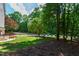Expansive backyard featuring mature trees and a play area, ideal for outdoor activities and relaxation at 101 Eden Glen Dr, Holly Springs, NC 27540
