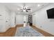Open concept bonus room with hardwood floors, built in shelves, a ceiling fan and a tv at 101 Eden Glen Dr, Holly Springs, NC 27540