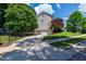 Spacious driveway leading to a two-car garage, surrounded by lush greenery and mature trees at 101 Eden Glen Dr, Holly Springs, NC 27540