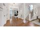 Bright foyer with hardwood floors, staircase, and view into the living and dining rooms at 101 Eden Glen Dr, Holly Springs, NC 27540